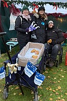 Drei Menschen auf dem Weihnachtsmarkt am Stand der BSG Weiterstadt mit Lebkuchenherzen und Simulationsbrille